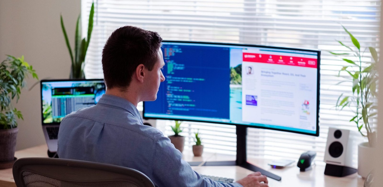 man in gray dress shirt sitting on chair in front of computer monitor